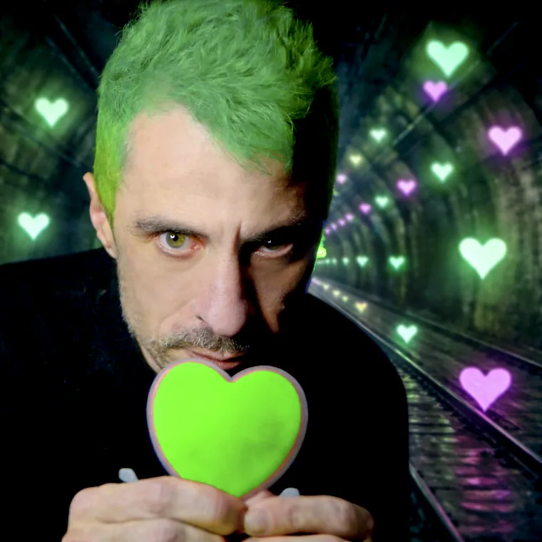 El Dr. Caudevilla sostiene un corazón verde en un túnel iluminado con corazones de neón